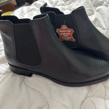 une bottine noire  en cuir avec un effet texturé façon peau de serpent. 👢