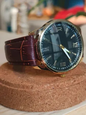 Montre marron, noire, dorée, arrondie, rétro