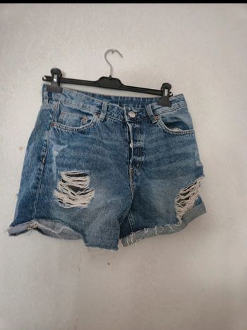 Short bleu en jean effet troué, excellent état. Taille 36