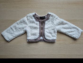 Boléro / Gilet en fausse fourrure blanche Chicaprie - 12 moisVends ce ravissant petit boléro à manches longues de la marque Chicaprie. Parfait pour compléter une tenue de cérémonie (baptême, mariage) ou pour garder bébé bien au chaud avec élégance.
​Taill
