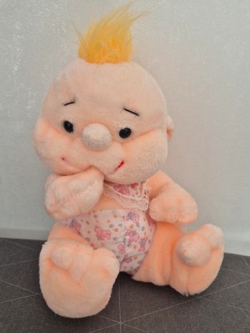 Peluche bébé qui suce son pouce