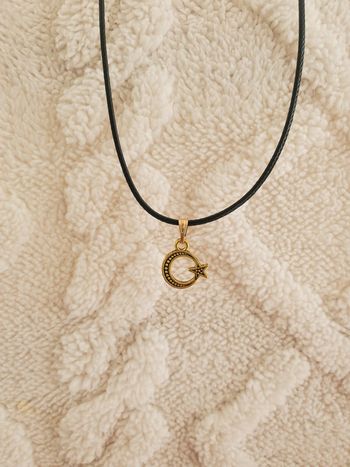 Collier avec un pendentif en forme de lune étoile doré