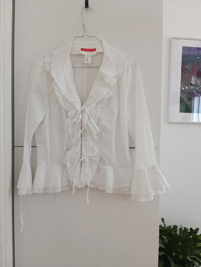 Blouse blanche à froufrous et nouettes