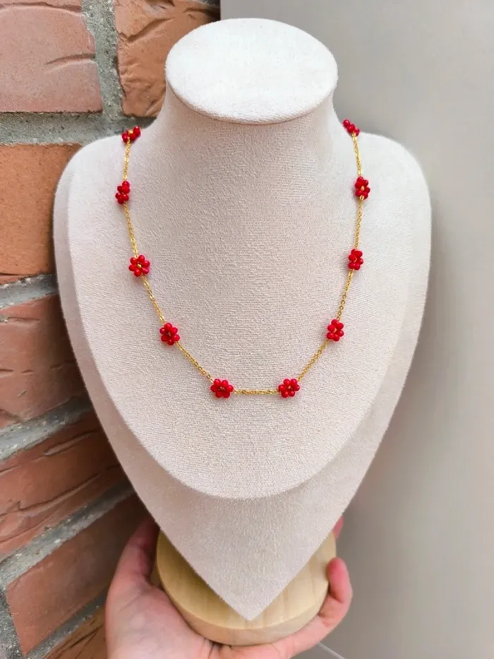 Collier doré avec fleurs marguerites rouges foncées