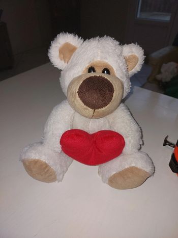Peluche nounours tenant un cœur rouge