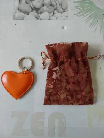Joli porte clé en cuir cœur orange et son pochon NEUF