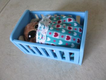 Petit nounours dans son lit avec accessoires