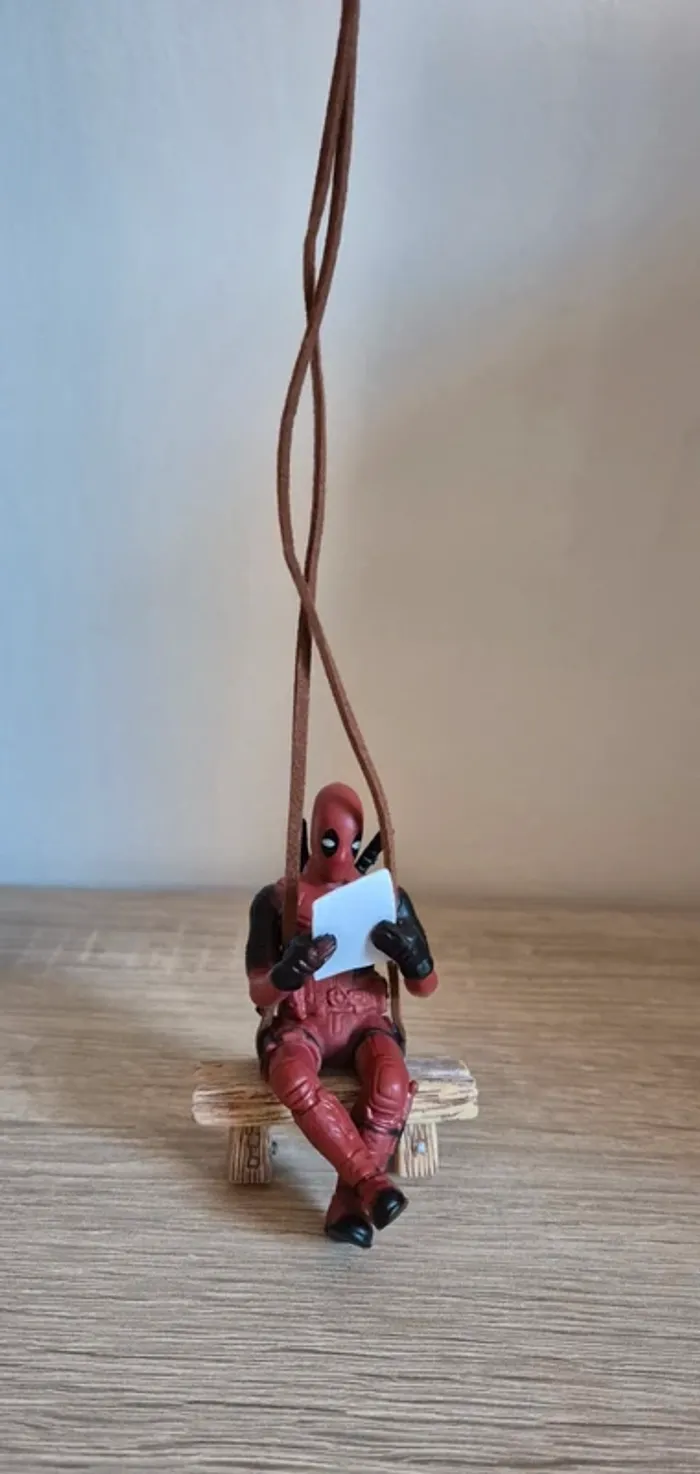 Figurine DeadPool suspendu assis sur un banc. - photo numéro 3