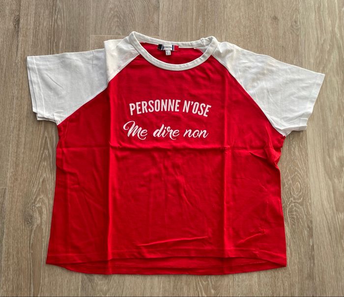 Tee shirt rouge avec manches blanches  avec inscription taille L.