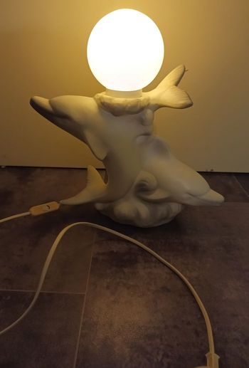 Lampe d'ambiance (ballet de Dauphins en faïence et globe en opaline)