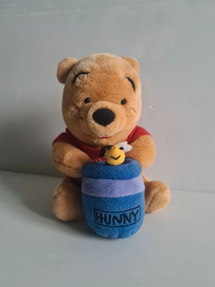Peluche Winnie l'ourson avec son pot de miel 18cm