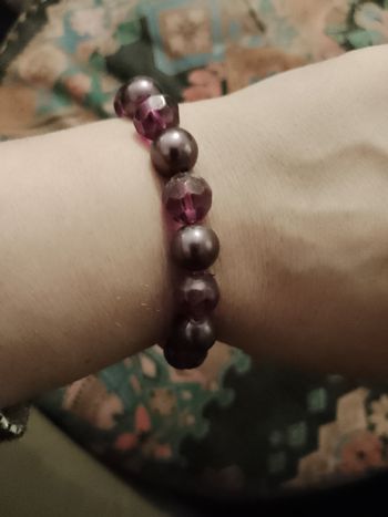 bracelet en perles de plastique noires/ violettes.