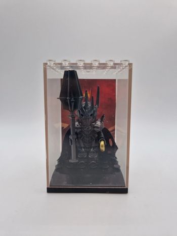 Figurine type lego Sauron seigneur des anneaux dans une vitrine individuelle avec fond