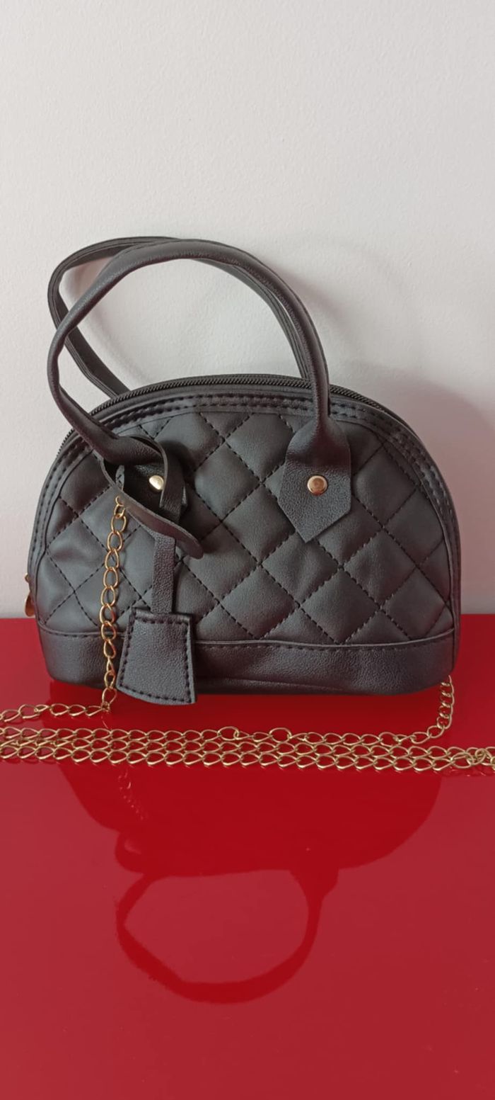 Petit sac à main noir avec bandoulière dorée