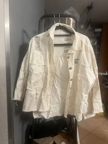 Blouson en jean déchiré et article de journal