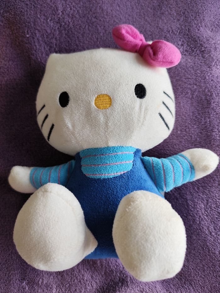 Peluche hello Kitty assise vêtement bleu noeud rose