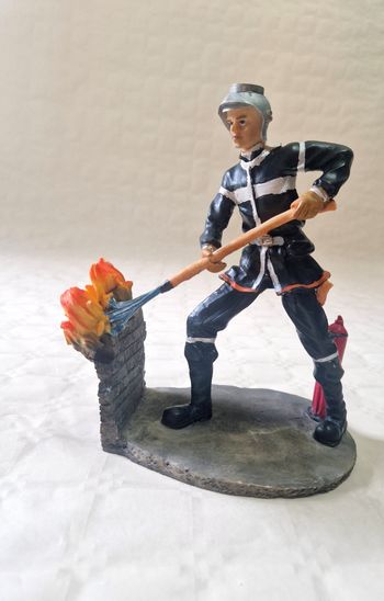 Figurine Sapeur pompier qui éteint un feu