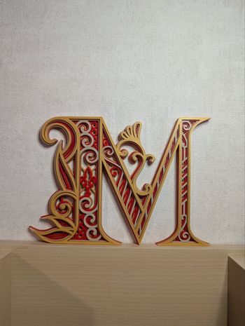Lettre M décorative en relief, initiale enluminée
