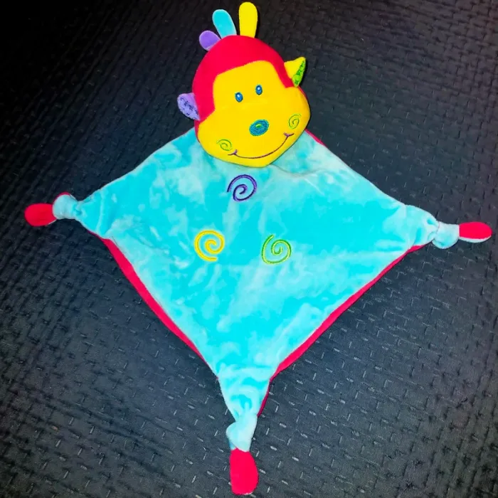 Doudou singe grelot dans la tête bleu, rouge spirale CP International
