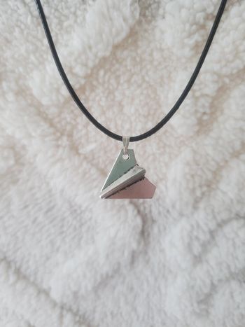 Collier avec un pend et en forme d'avion en papier