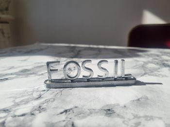Plaque d'enseigne Fossil en métal 