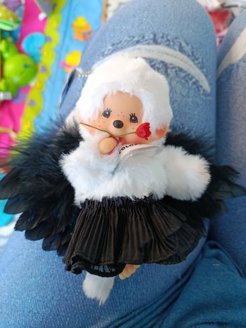 Monchhichi blanc avec des ailes noires et une rose rouge a la bouche