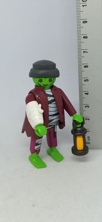 Homme zombie à tête verte avec lanterne et plâtre playmobil