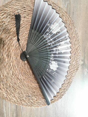 Éventail style japonais fleurs blanches et fond noir