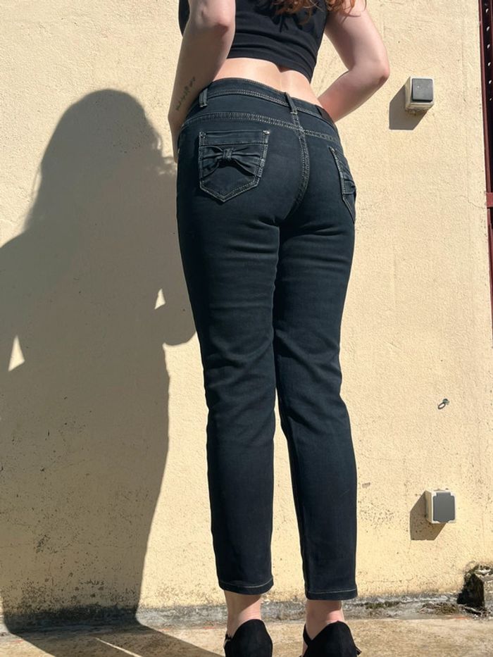 Jean slim droit taille normale avec noeud papillon sur poches arrières.