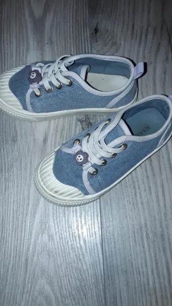 Chaussures bleues avec une petite fleur en plastique accroché au lacet taille 26