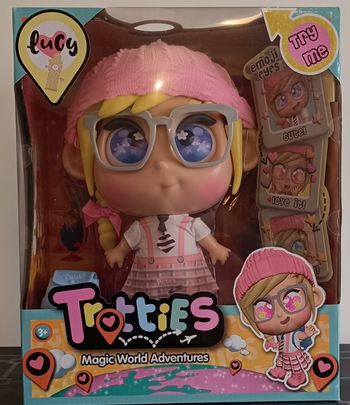 Poupée Trotties Lucy 25 cm – Série Animée Magique de Londres avec Yeux Émoji + Sac Bleu