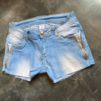 Short en jeans stretch dentelle blanche sous les poches 40