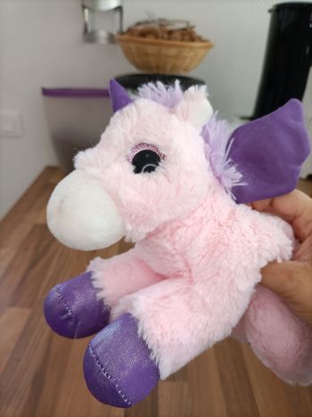 Jolie peluche licorne volante rose et violette avec des ailes