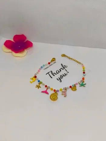 Bracelet doré et multicolore avec perles de cristal et breloques de la mer