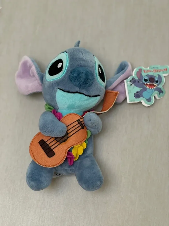 Peluche Stitch avec guitare banjo yukelele et collier hawaïen Lilo et Stitch Disney