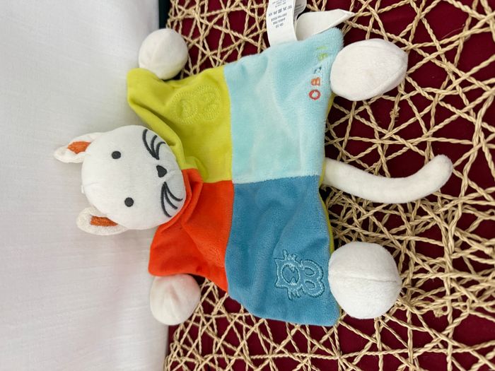 Doudou plat chat blanc bleu vert rouge OBAIBI