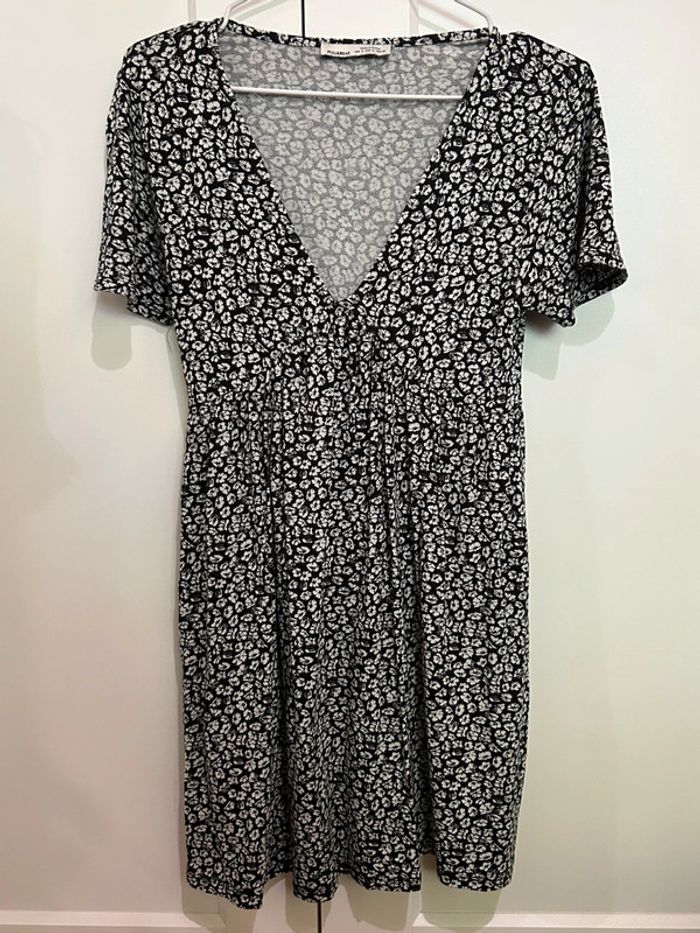671 – robe fluide à manches courtes, col v et taille cintrée noire et fleurie blanche Pull&Bear
