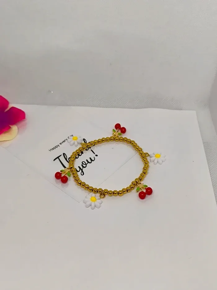 Bracelet doré élastique avec breloques cerises et marguerites blanches - photo numéro 2