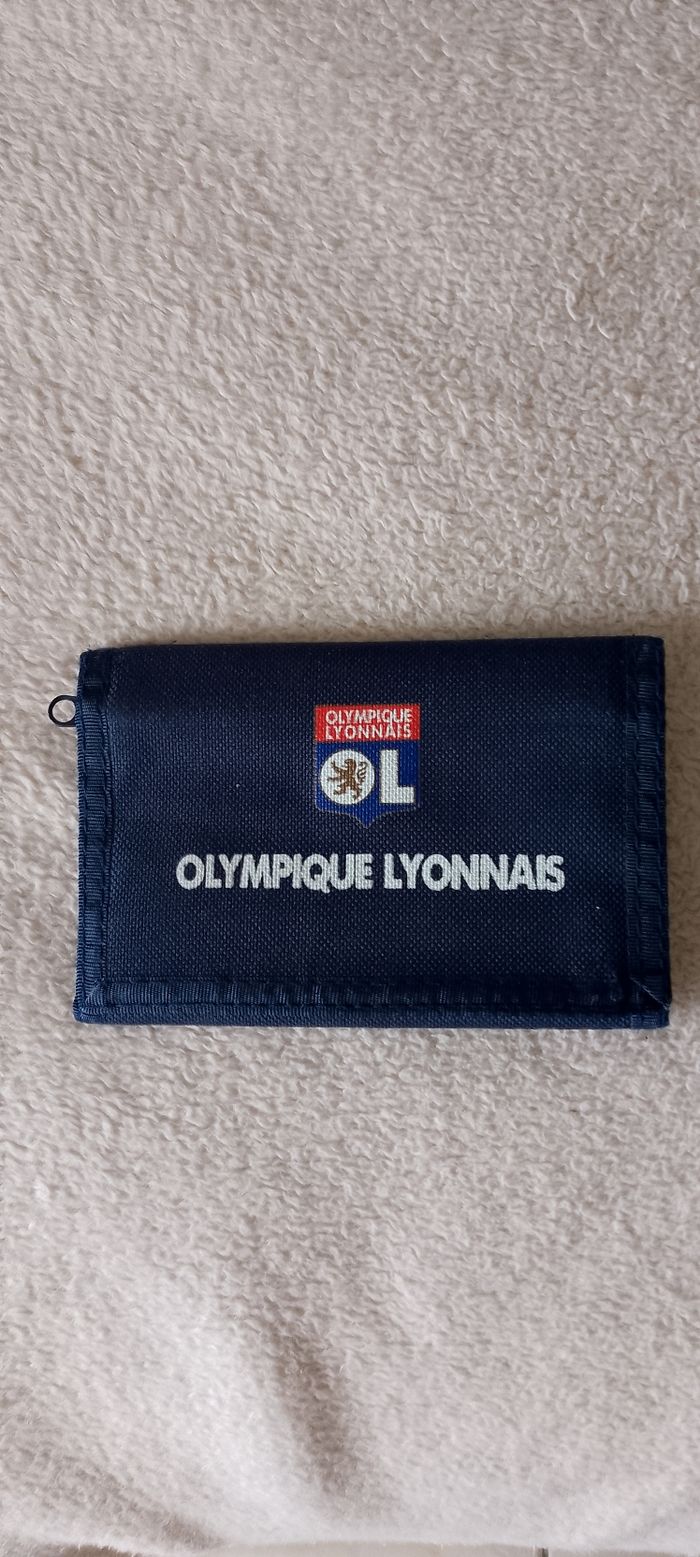 Joli porte feuille olympique lyonnais. Fermeture scratch. Plusieurs poches dont une a fermeture éclair. neuf