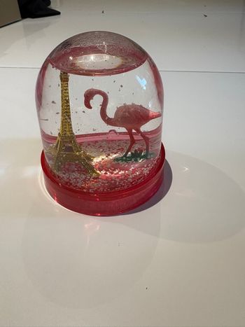 Boule de neige rose représentant la Tour Eiffel et un flamant rose
