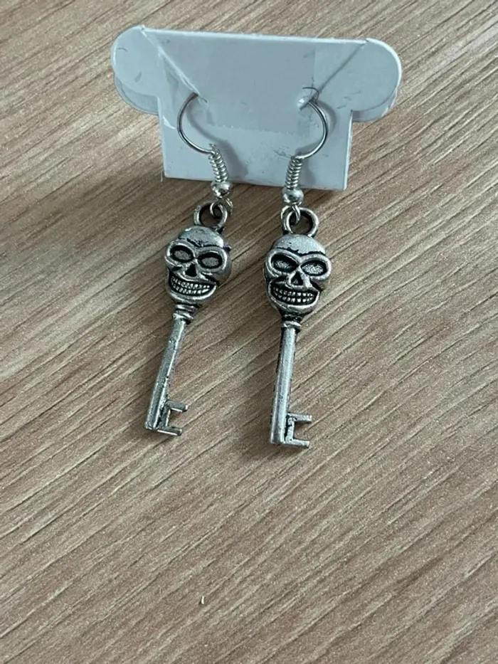 Boucle d’oreille clé tête de mort argenté
