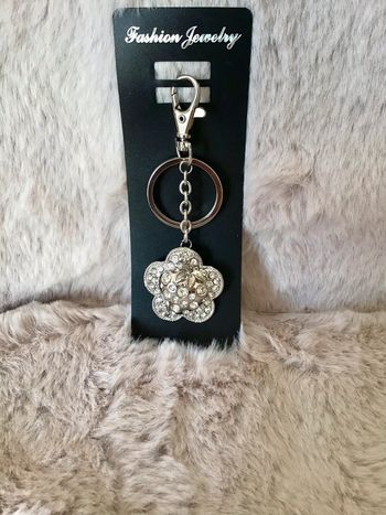 Jolie porte clef en métal argenté et strass fleur fraise (0124)