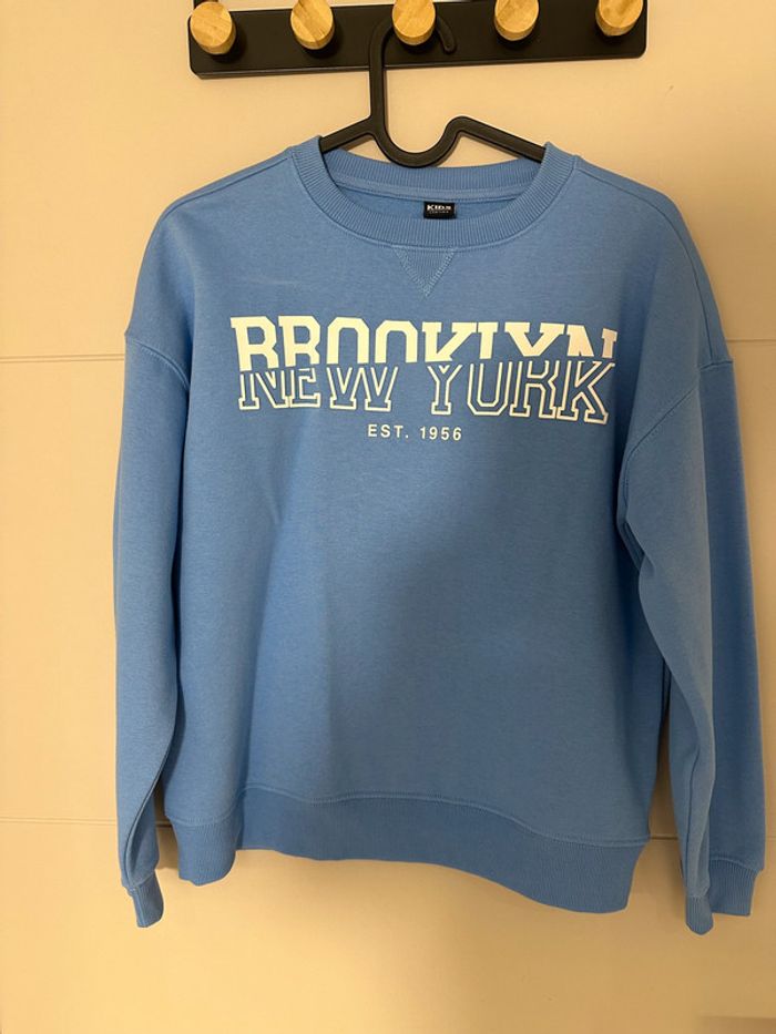Sweat bleu à écriture blanche – taille 146/152 (10-12 ans)