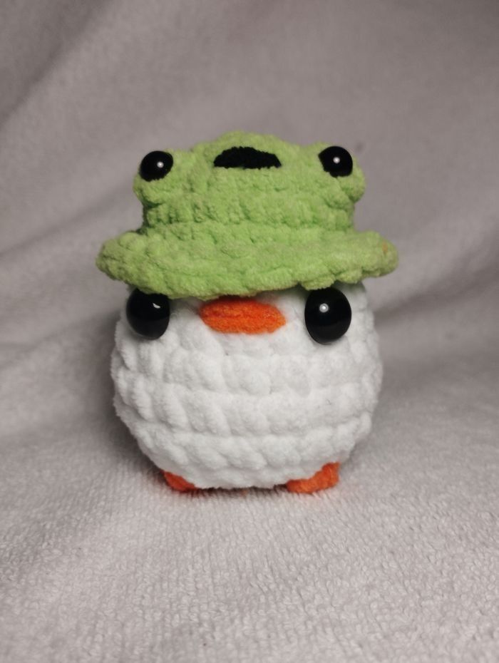 Petite peluche poussin au chapeau grenouille