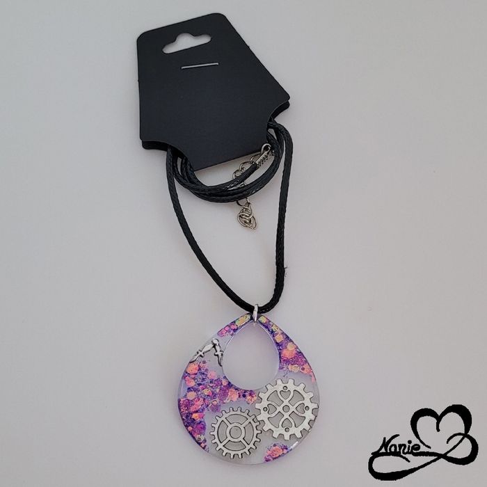 Pendentif transparent avec des engrenages et des paillettes violettes