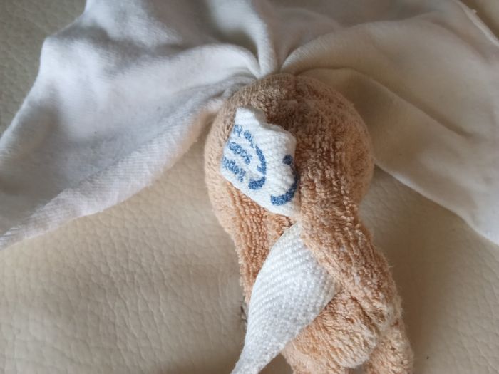 Doudou keptin-jr  poupée lutin pantin  beige blanc crème marron clair sans  visage d'occasion noeuds extrémités défaits  anneau en bois  grelot hochet fonctionne  dans sa tête tissu triangle  bonnet  avec  2 noeuds - photo numéro 2