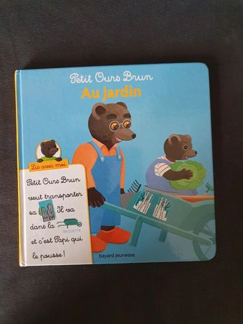 Livre petit ours brun au jardin