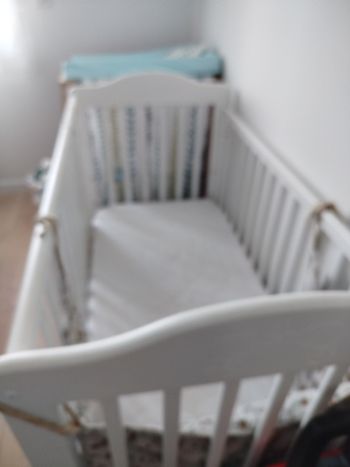 Lit a barreaux bois repeint en blanc sauf le sommier qui n'a pas été peint 