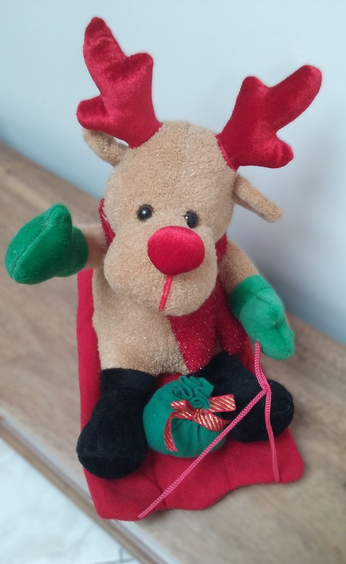 Petit renne peluche sur sa luge