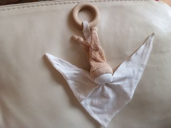 Doudou keptin-jr  poupée lutin pantin  beige blanc crème marron clair sans  visage d'occasion noeuds extrémités défaits  anneau en bois  grelot hochet fonctionne  dans sa tête tissu triangle  bonnet  avec  2 noeuds
